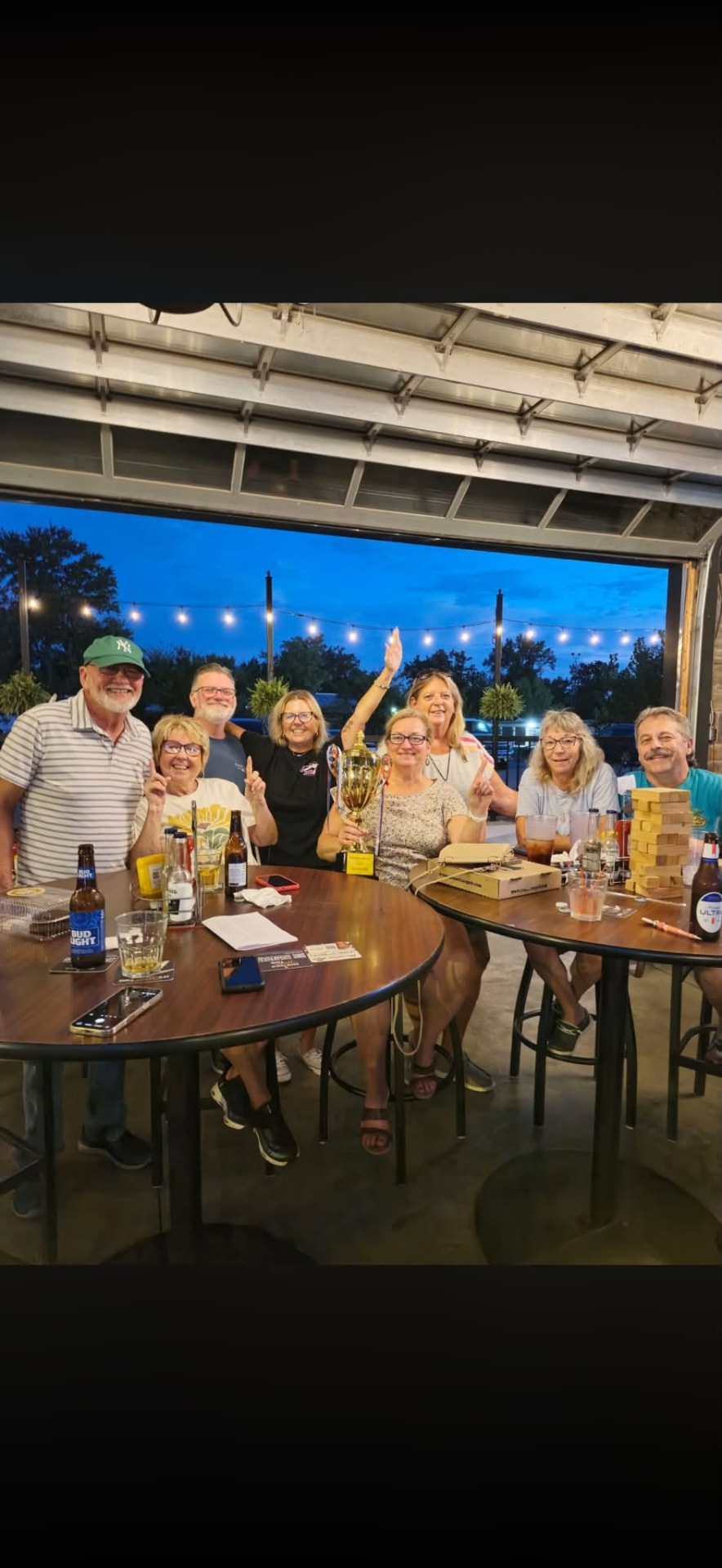 Trivia winners celebrating with a trophy at J's