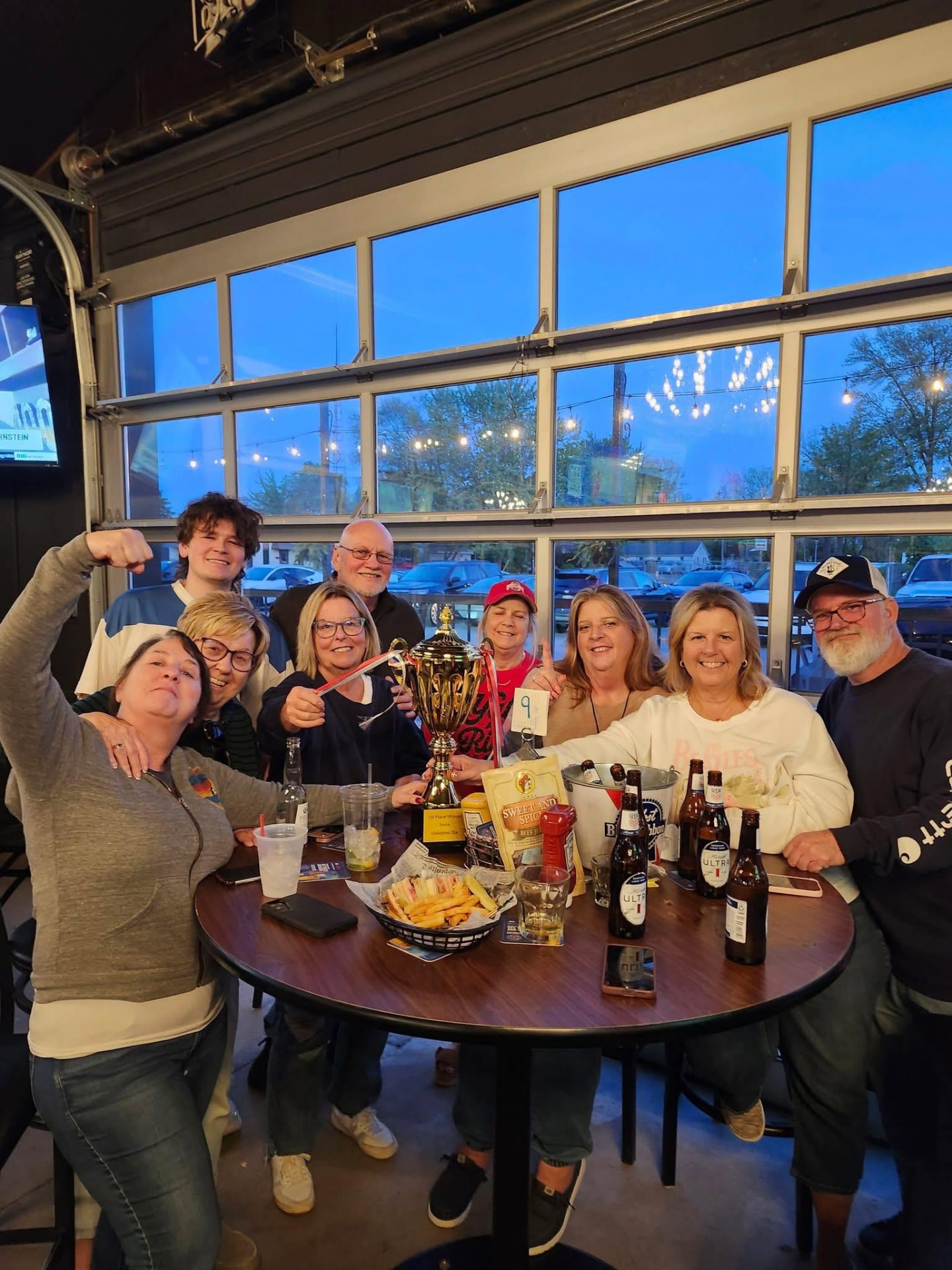 Trivia winners celebrating with a trophy at J's