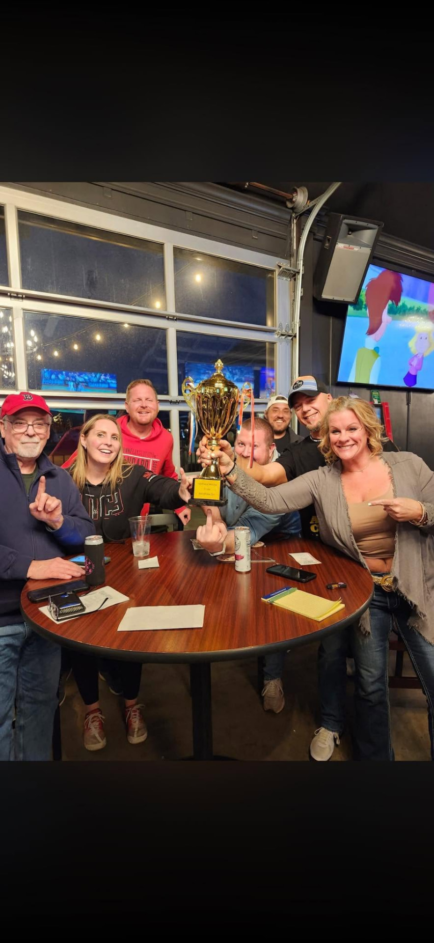 Trivia winners celebrating with a trophy at J's