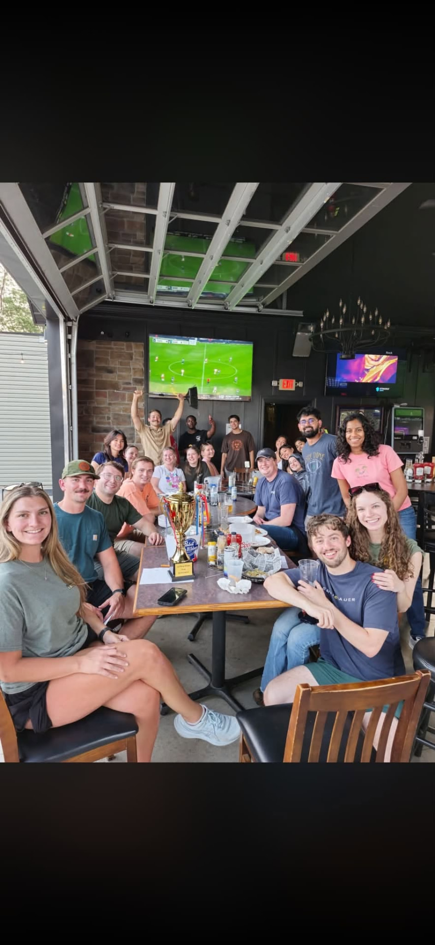 Trivia winners celebrating with a trophy at J's